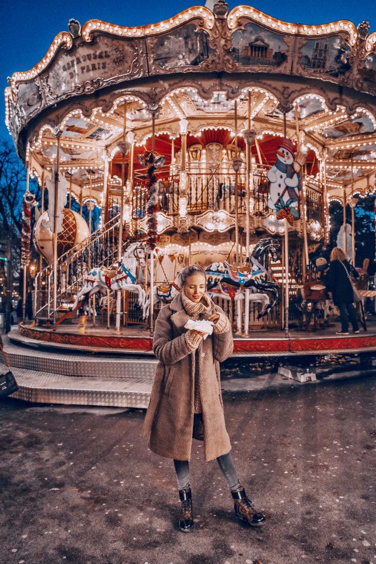 a woman standing in front of a merry go round