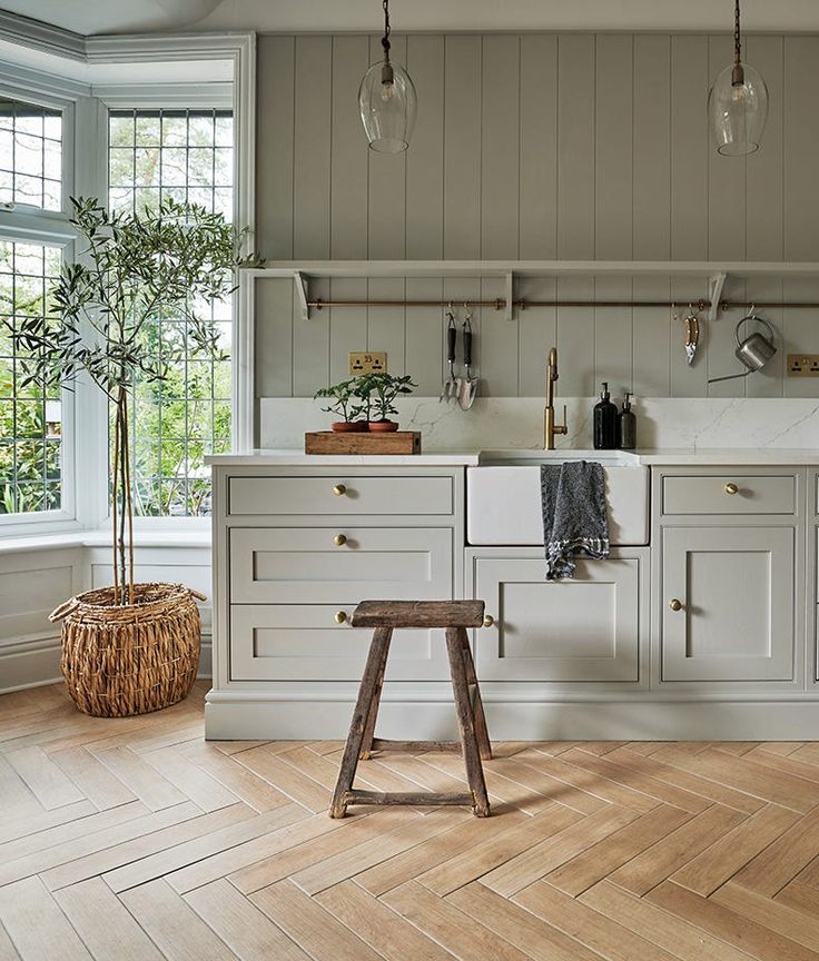 an image of a kitchen with white cabinets and wood flooring on the bottom right hand corner