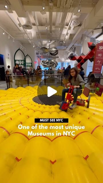 a woman sitting on top of a giant inflatable object with people standing around it