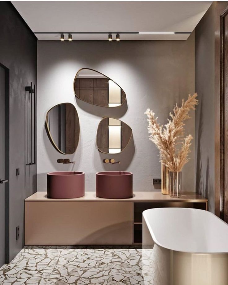 a bathroom with two sinks and mirrors on the wall next to a white bathtub