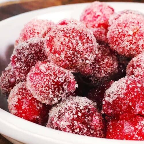 a white bowl filled with powdered sugar covered raspberries