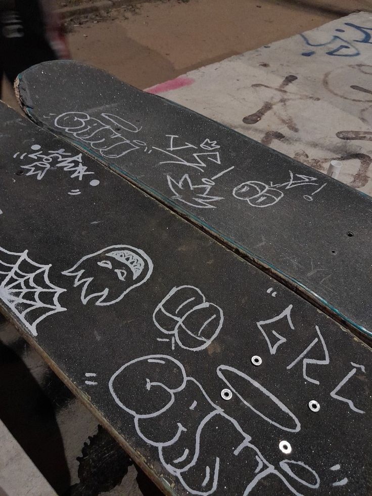 two skateboards with graffiti written on them