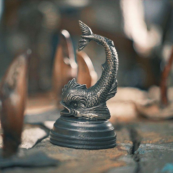 a fish statue sitting on top of a wooden table