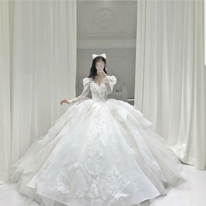 a woman in a white wedding dress is posing for the camera with her hands on her face