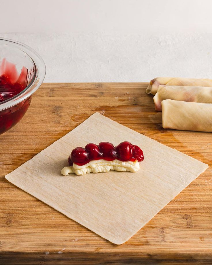 a wooden cutting board topped with bananas and cherries