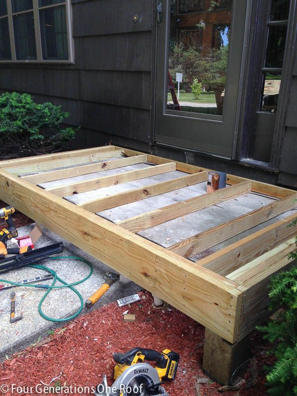 a wooden deck being built in front of a house