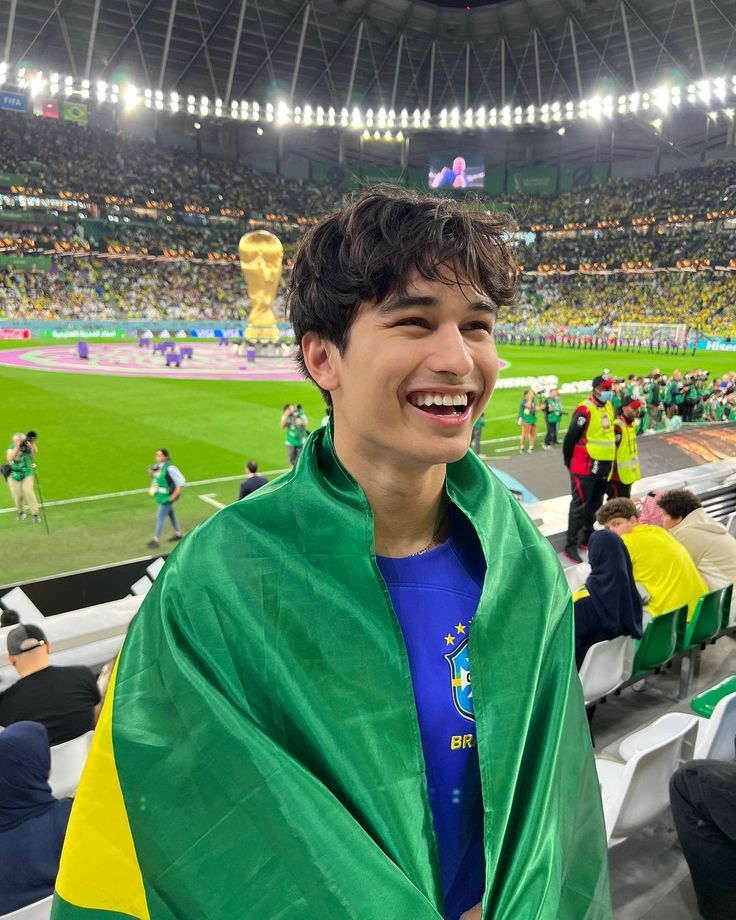 a man wearing a green and yellow cape at a soccer game