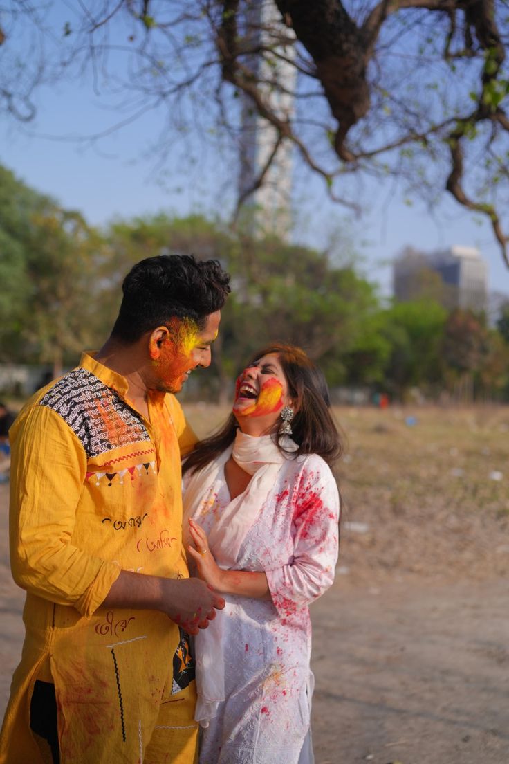 a man and woman standing next to each other with paint on their faces in front of them