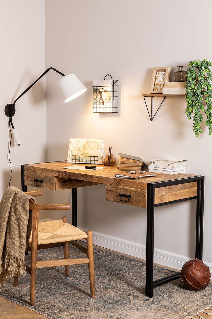 a wooden desk with a lamp on top of it next to a chair and table