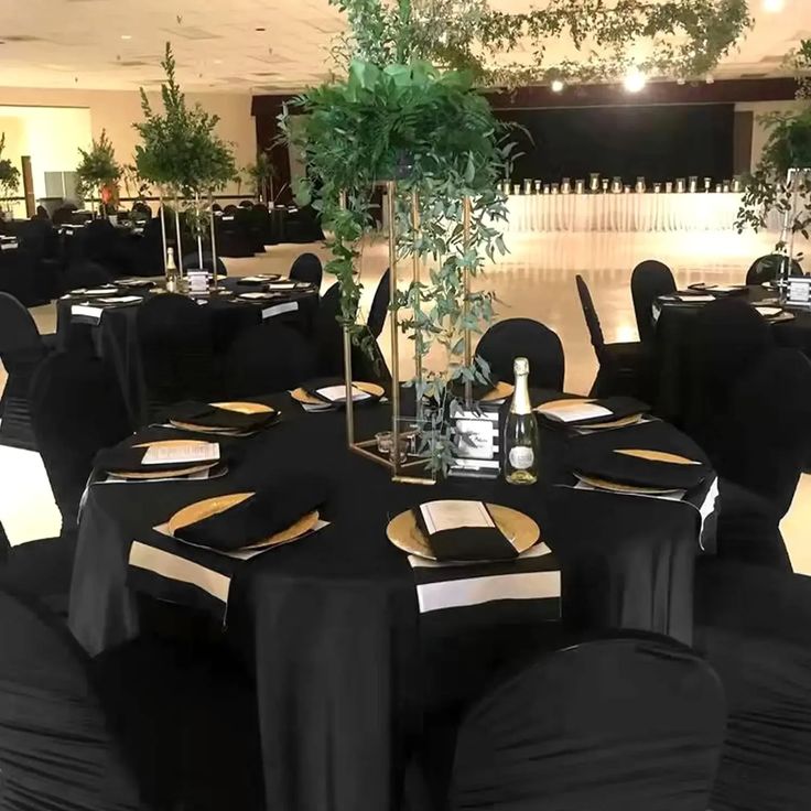 tables with black linens and gold trim are set up for an event