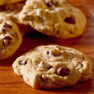 three chocolate chip cookies on a wooden table