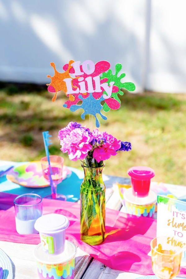 there is a vase with flowers in it and some cards on the table next to it