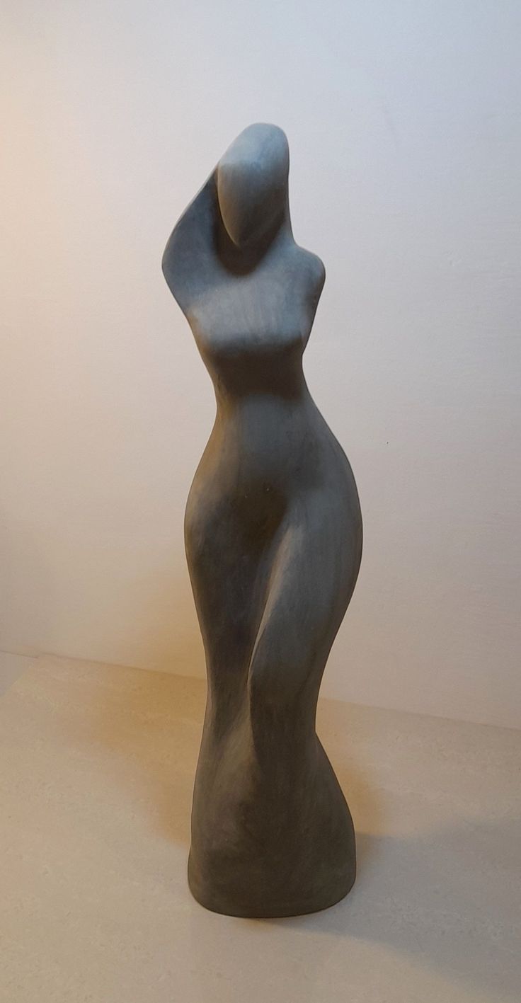 a gray sculpture sitting on top of a white table