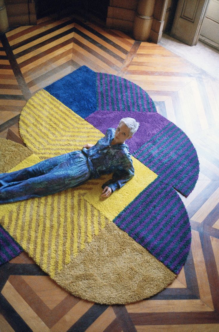 a doll laying on top of a colorful rug