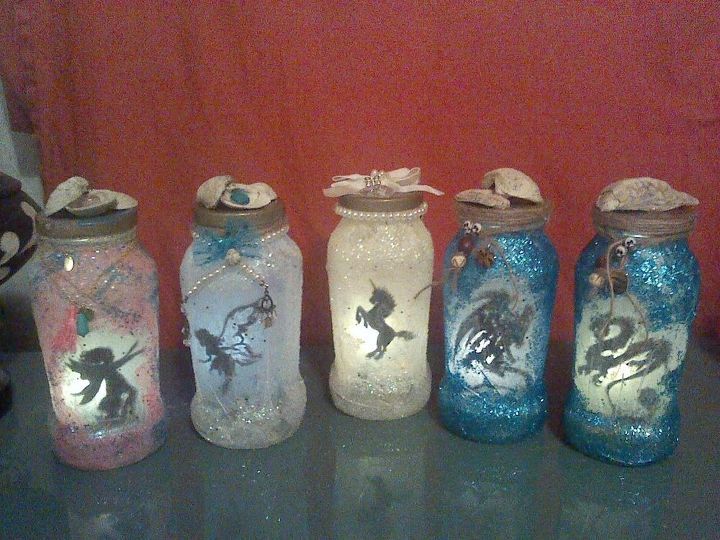 five jars with fairy tale images are lined up in a row on a table next to a red wall