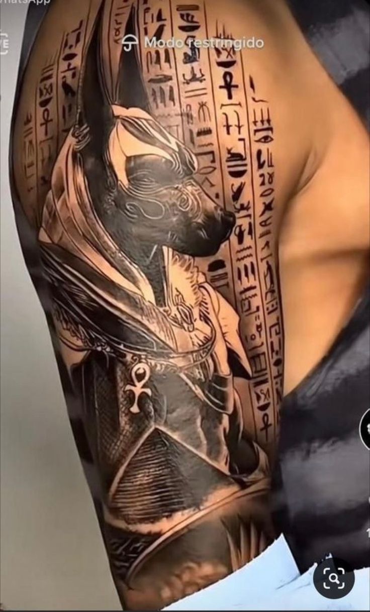 an egyptian tattoo on the back of a man's arm