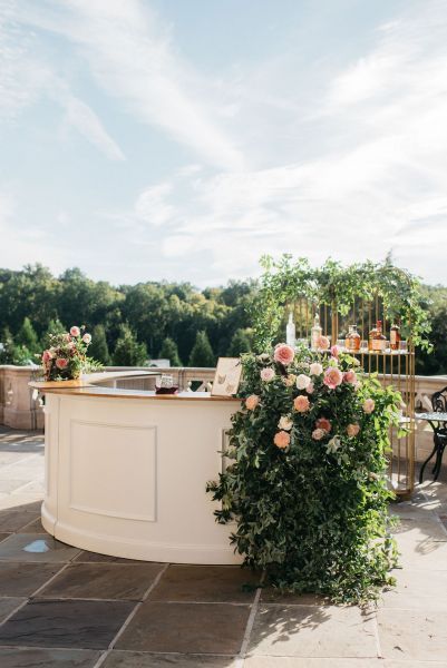 an outdoor bar with flowers and greenery on it