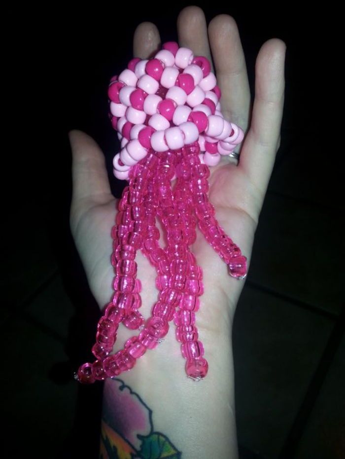 a hand with pink and white beads on it