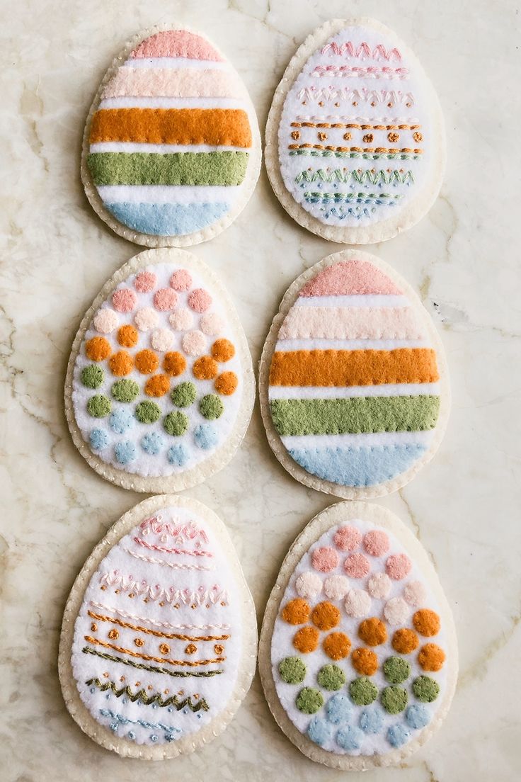 four decorated cookies sitting on top of a counter