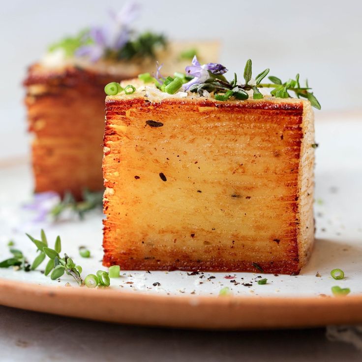 two pieces of cake sitting on top of a white plate covered in green and purple flowers