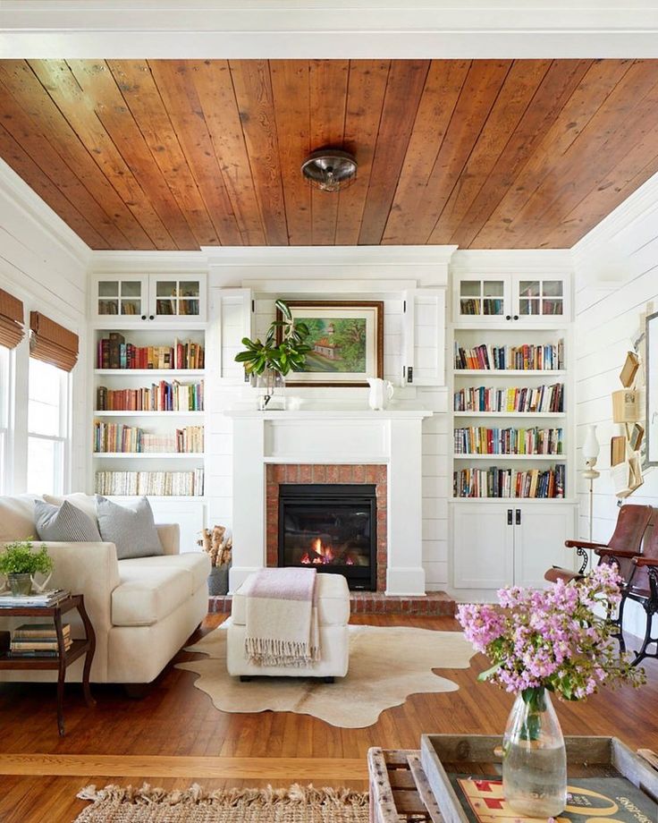 a living room filled with furniture and a fire place in the middle of a room