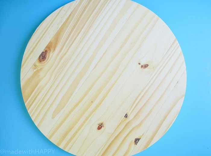 a round wooden board with holes in the middle on a blue background, top view