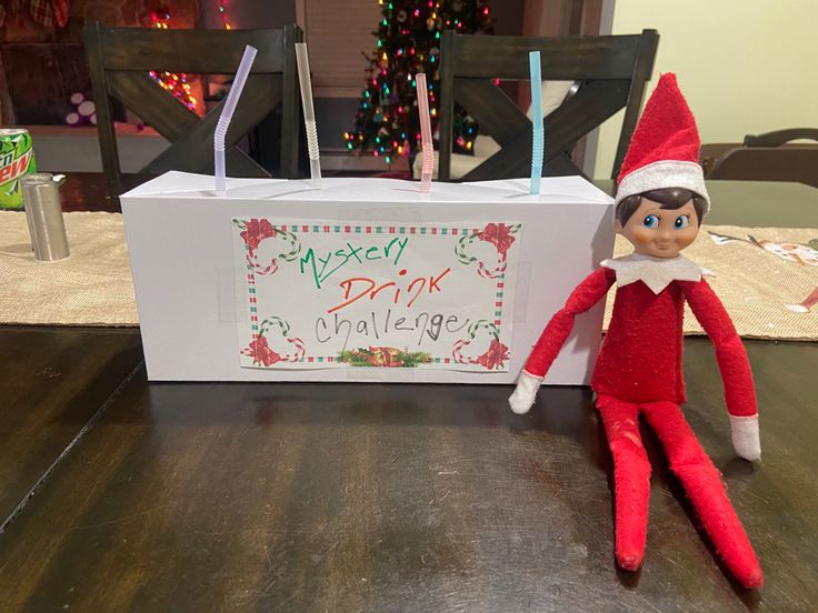 an elf is sitting on the table next to a box