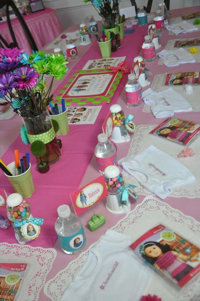 the table is set up with pink and green decorations, flowers, and other items