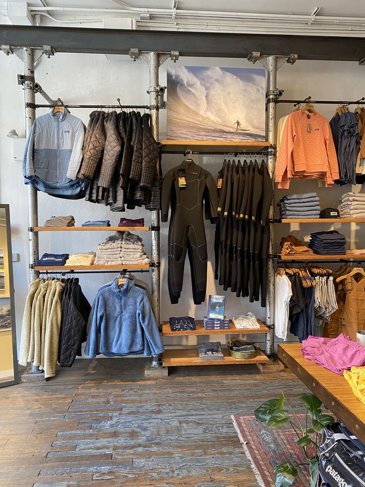 the inside of a clothing store with clothes on racks