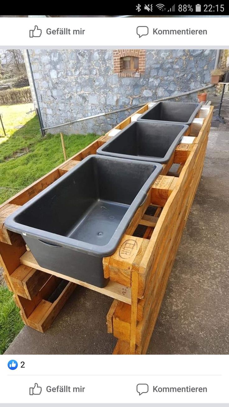 a wooden bench with two large plastic troughs on it