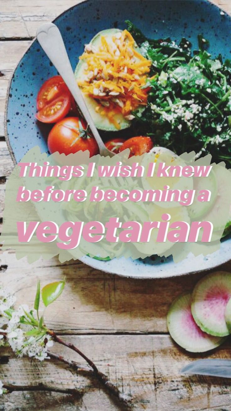 a bowl filled with vegetables on top of a wooden table next to a knife and fork