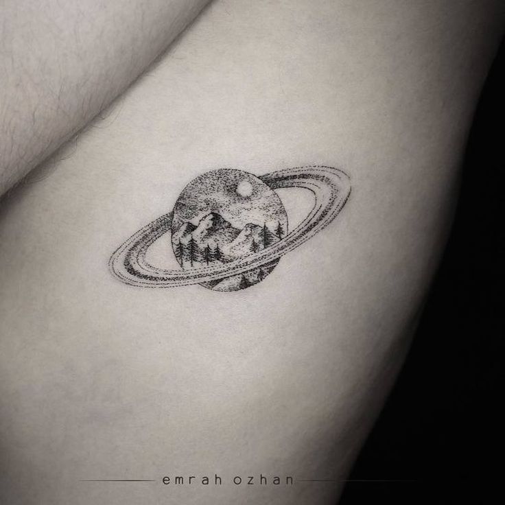 a small saturn tattoo on the back of a woman's left arm