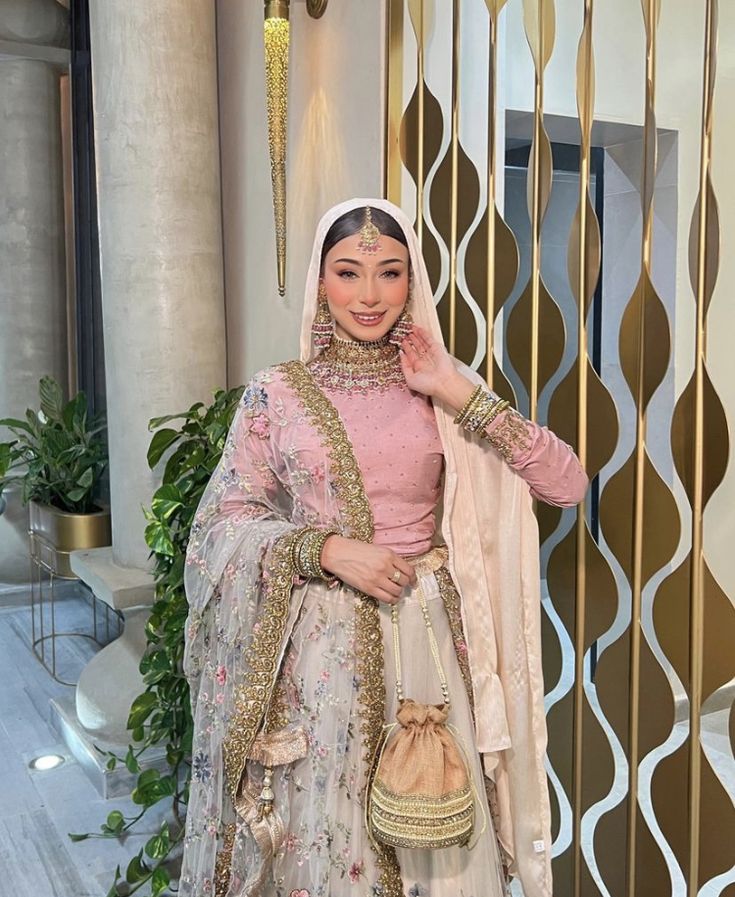 a woman in a pink and gold outfit posing for the camera