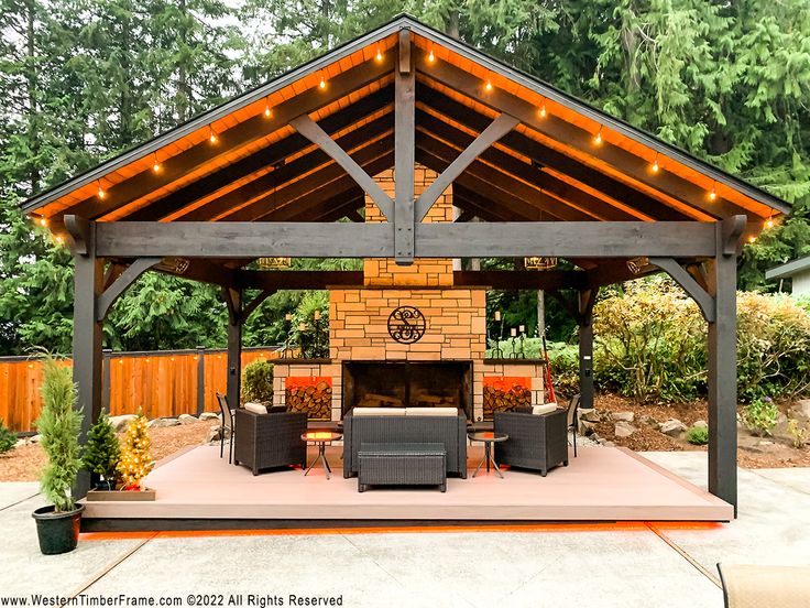 a covered patio with furniture and lights on the roof, surrounded by trees in the background