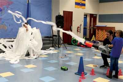 two children are playing with firecrackers on the floor in a school gym