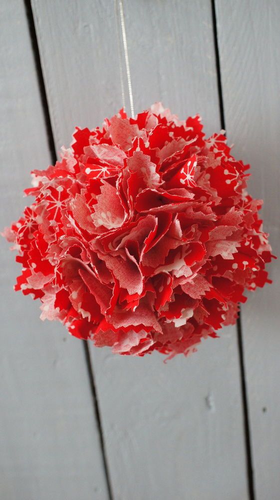 a red flower hanging from the side of a wooden wall