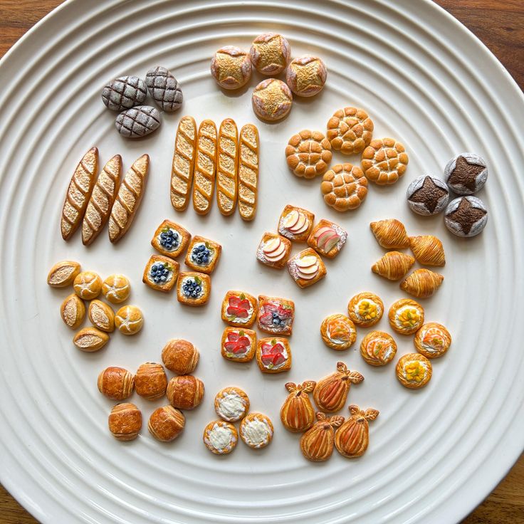 a white plate topped with lots of different types of cookies and pastries on top of it