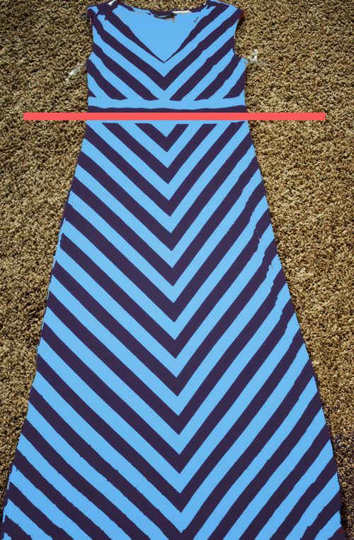 a blue and black dress laying on top of a brown carpet next to a red ribbon