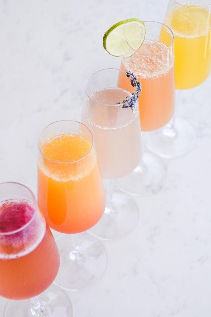 three glasses filled with different types of drinks next to each other on a white surface