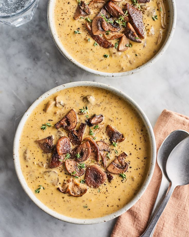 two bowls filled with soup on top of a table