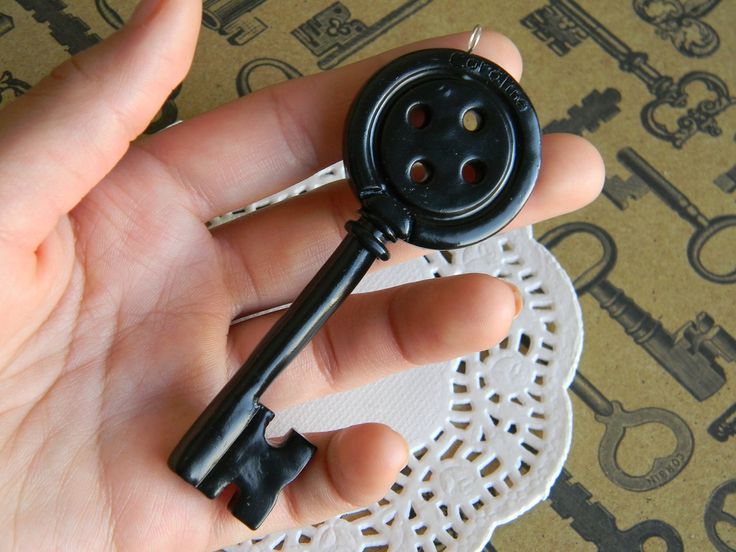 a person holding a small black button in their hand