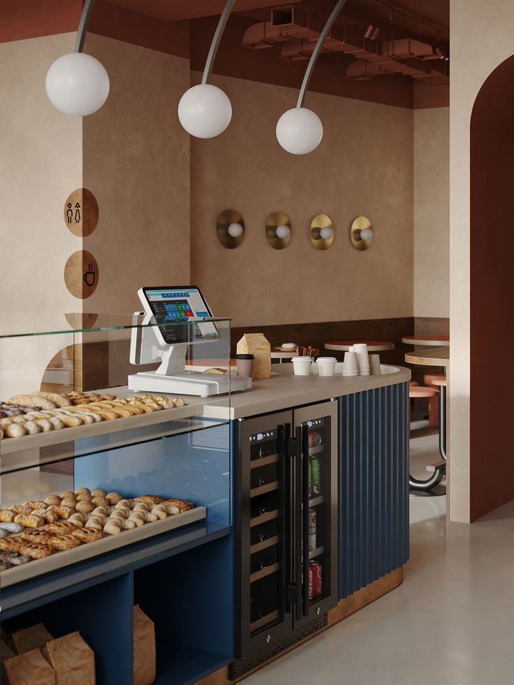 a bakery with lots of donuts on display behind the counter and lights above it