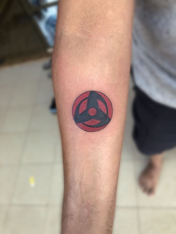 a man with a tattoo on his arm that has a red and black arrow in it