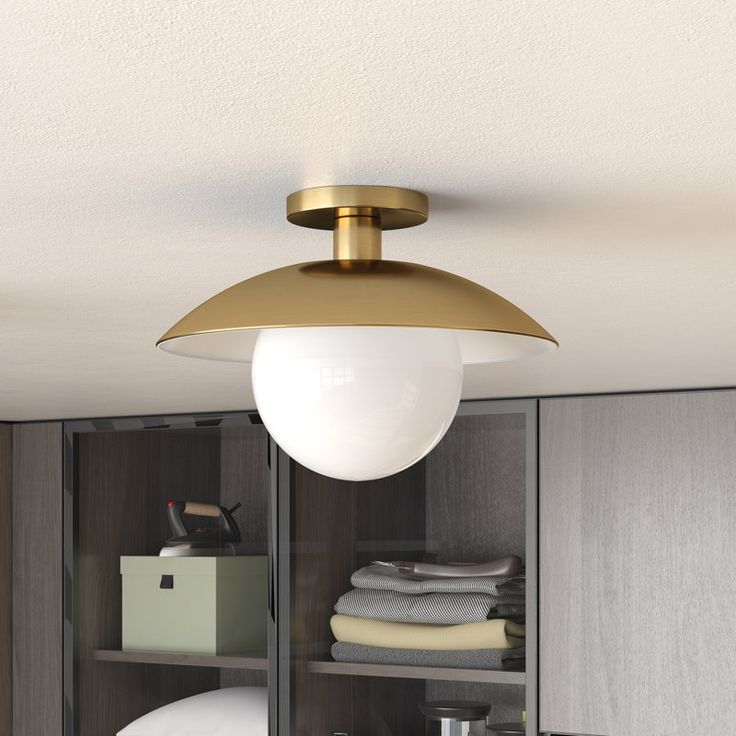 a light that is hanging from the ceiling in a room with some clothes on shelves