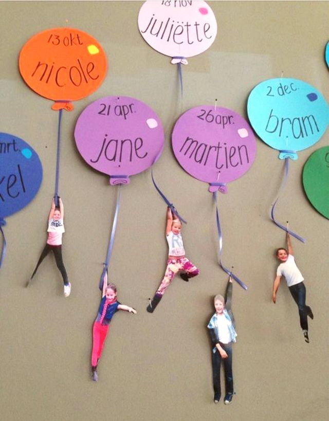 some people are hanging upside down on the wall with name tags attached to their heads