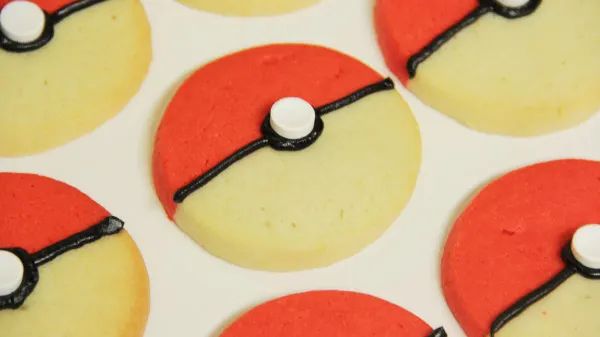 several decorated cookies in the shape of pokeballs