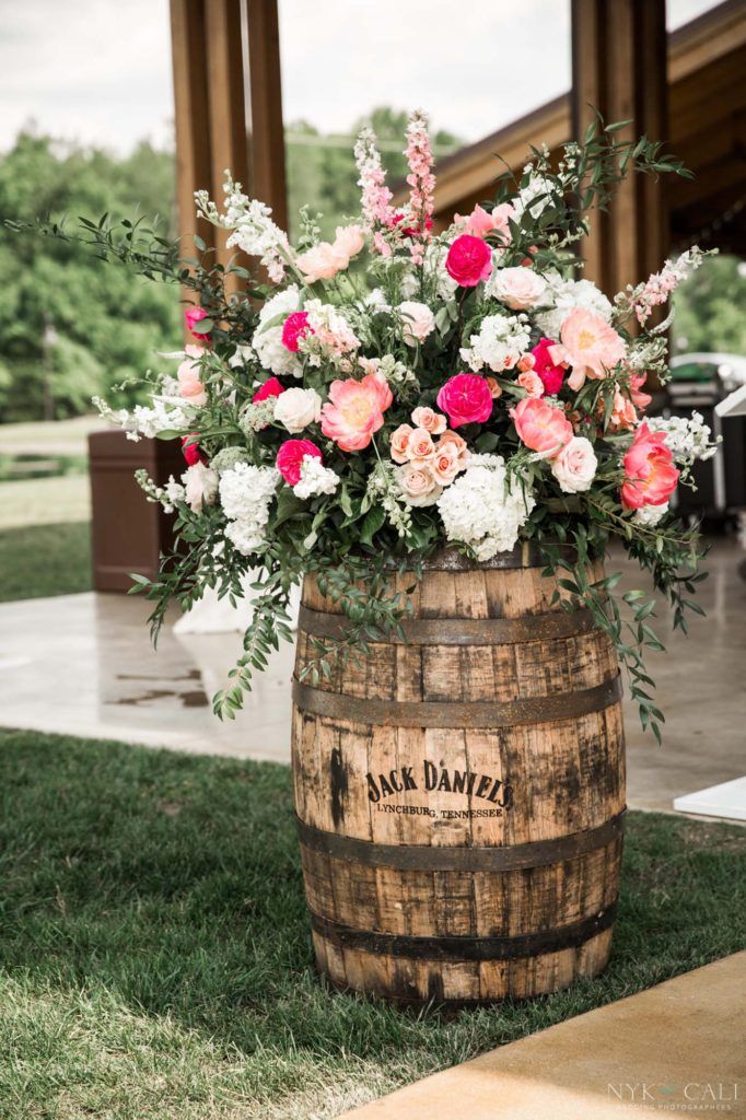 a wooden barrel with flowers in it on the grass