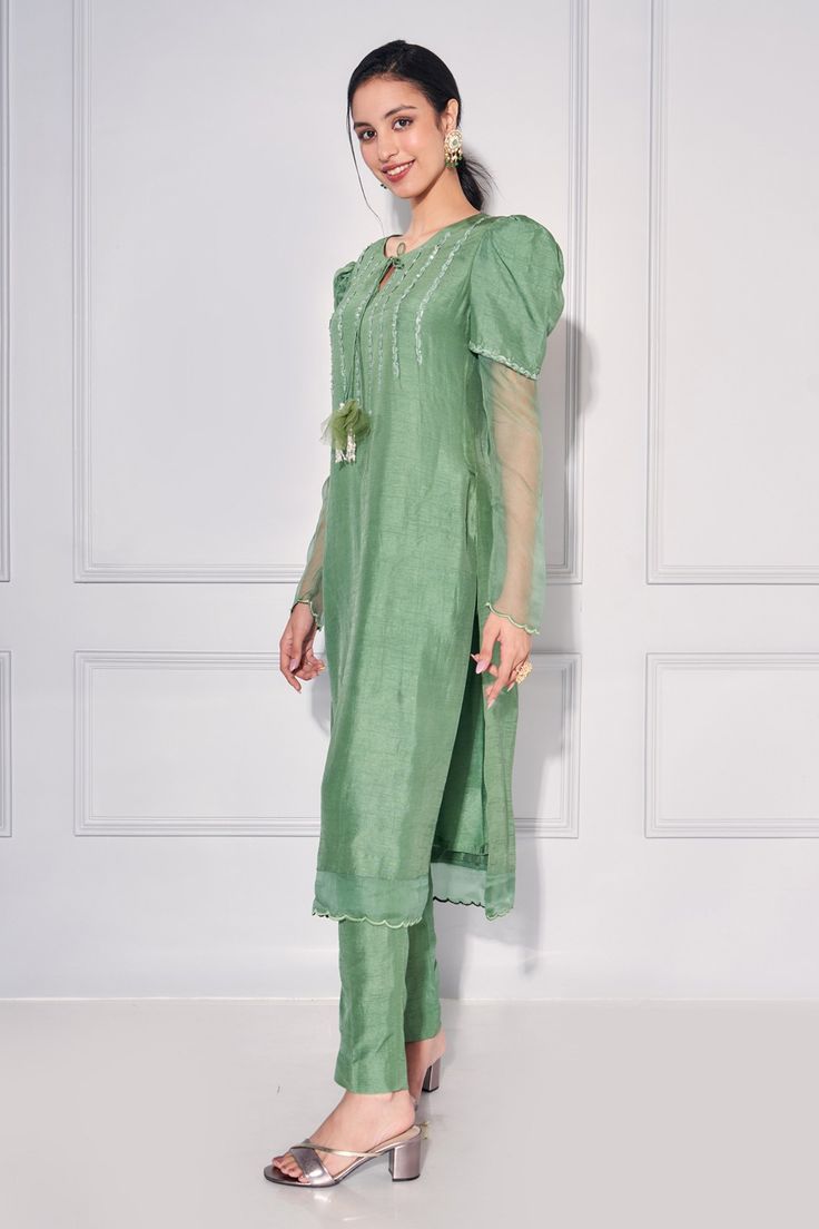 Sage green kurta featuring cutdana embellished detailing on bodice with tasselled tie. Comes with matching pant.
Components: 2
Pattern: Embroidered
Type Of Work: Sequin
Neckline: Round
Sleeve Type: Leg-of-mutton
Fabric: Dupion Silk,Organza
Color: Green
Other Details: 
Scalloped border
Attached lining
Occasion: Mehendi and Haldi,Sangeet - Aza Fashions Scalloped Border, Pant For Women, Dupion Silk, Straight Kurta, Kurta With Pants, Silk Organza, Fashion App, Embroidered Silk, Aza Fashion