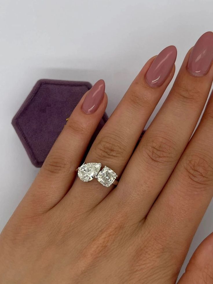 a woman's hand with two engagement rings on it