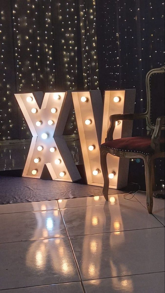 the letters x and y are lit up with lights in front of a chair on the floor